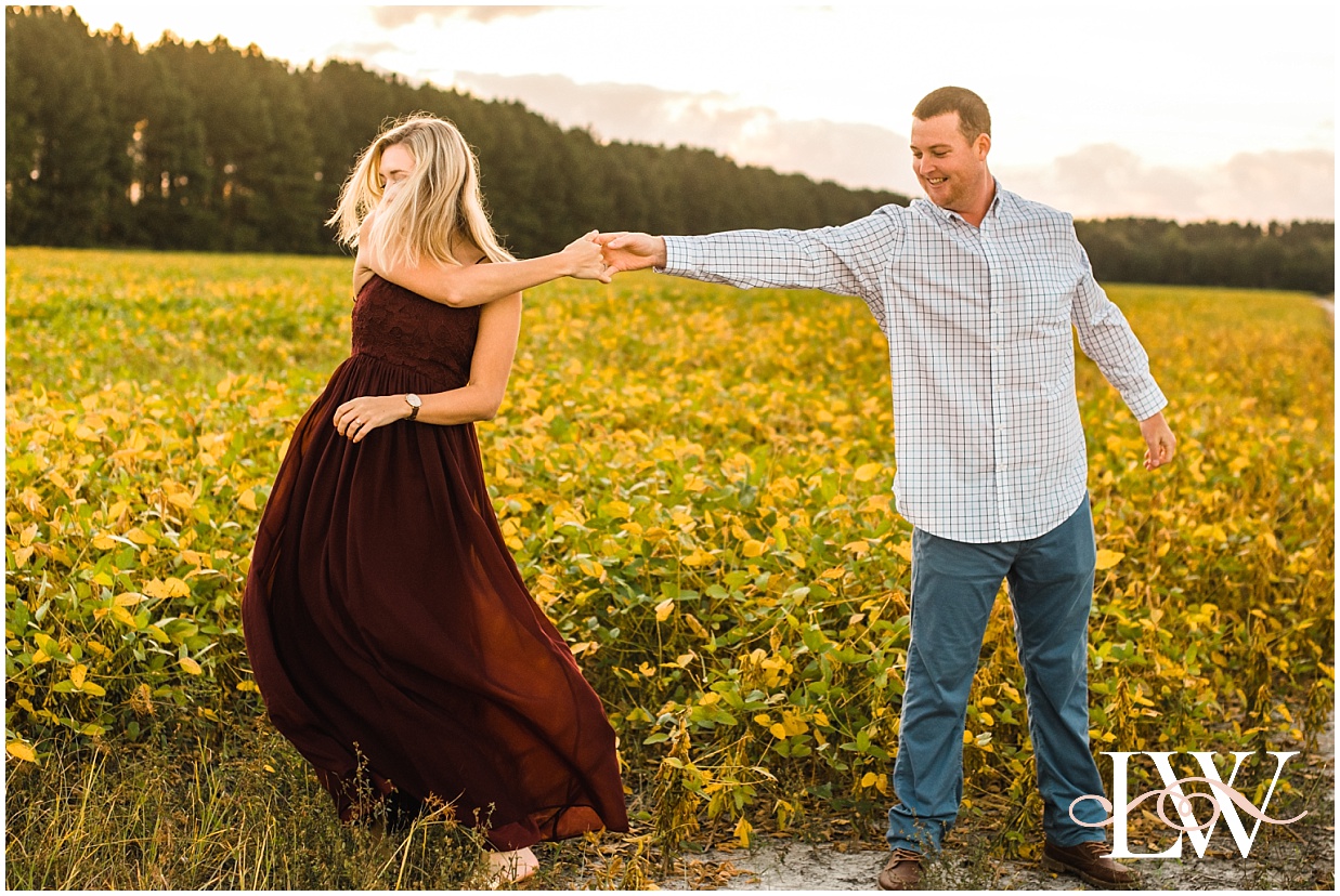 Engaged coupledancing in the farm field in Currituck, taken by Laura Walter Photography.