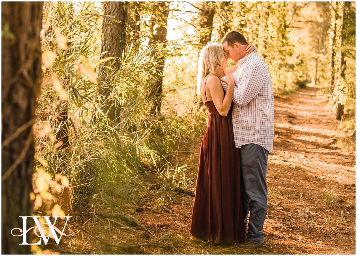 Currituck engaged couple snuggling in the forest at sunrise in North Carolina, taken by Laura Walter Photography