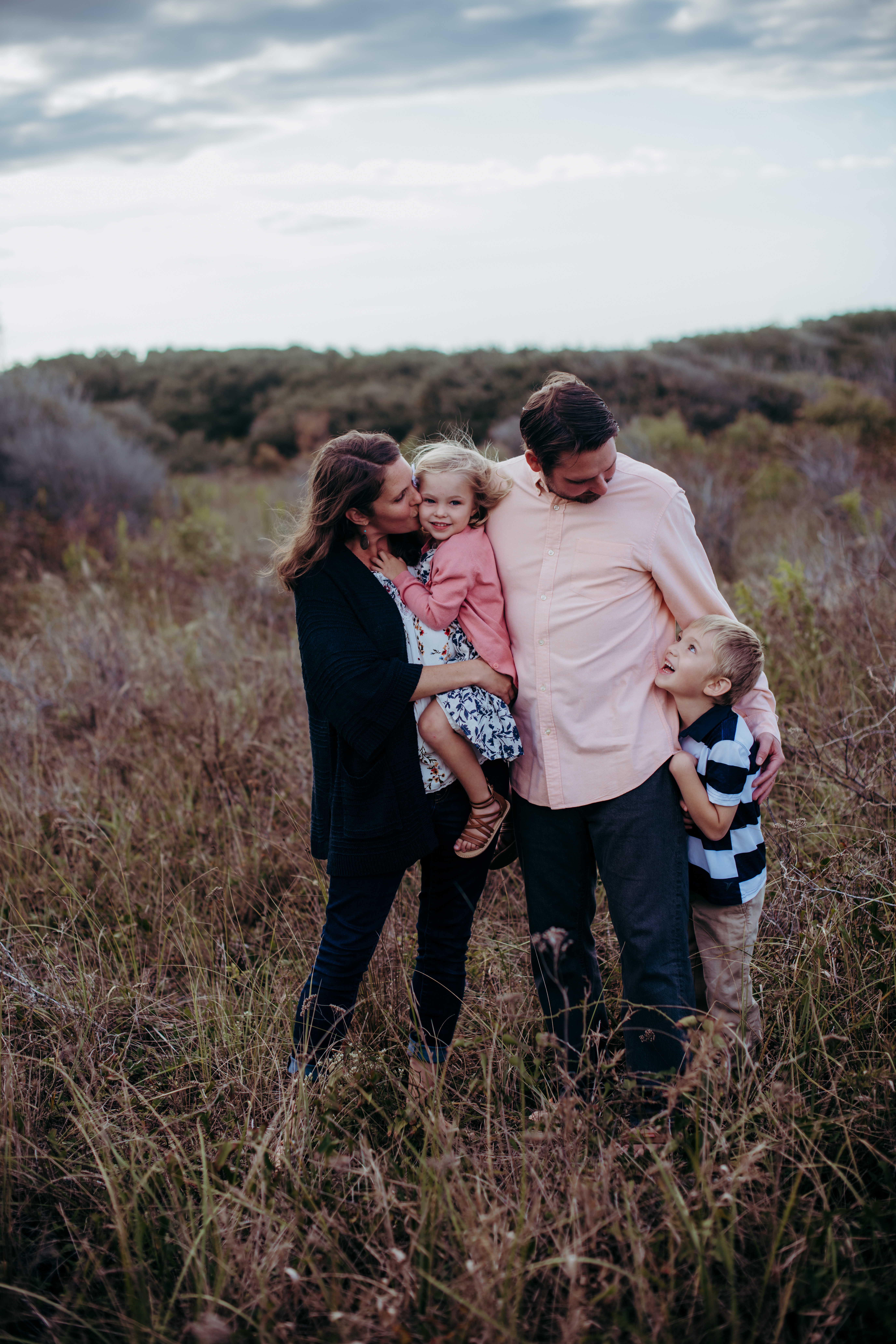 sweet family photo in a field of beach grass by laura walter photography