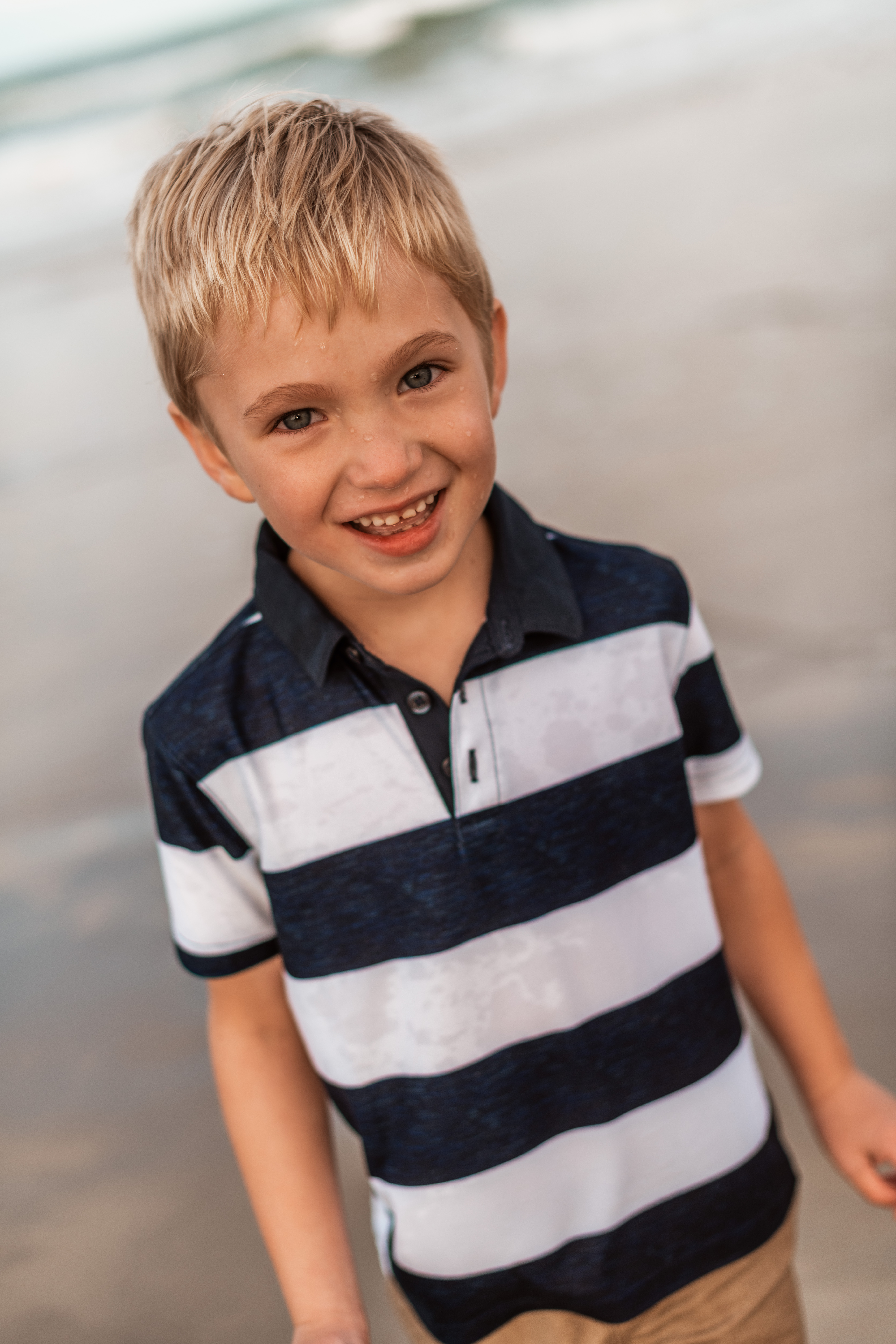 cute little boy headshot with ocean water on his face Outer Banks fun and natural family photographer Laura Walter